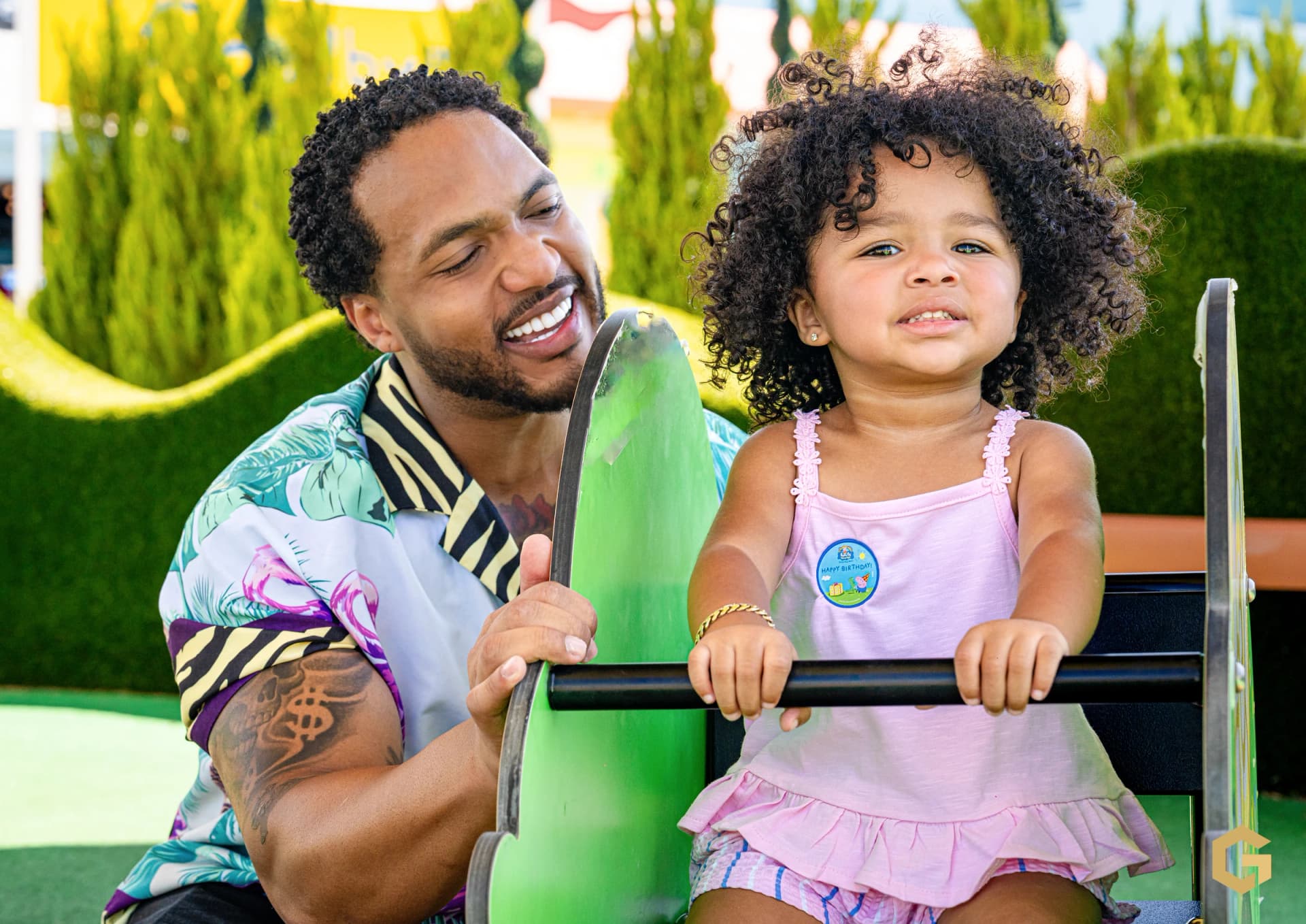 Father and daughter smiling together on a playground ride
