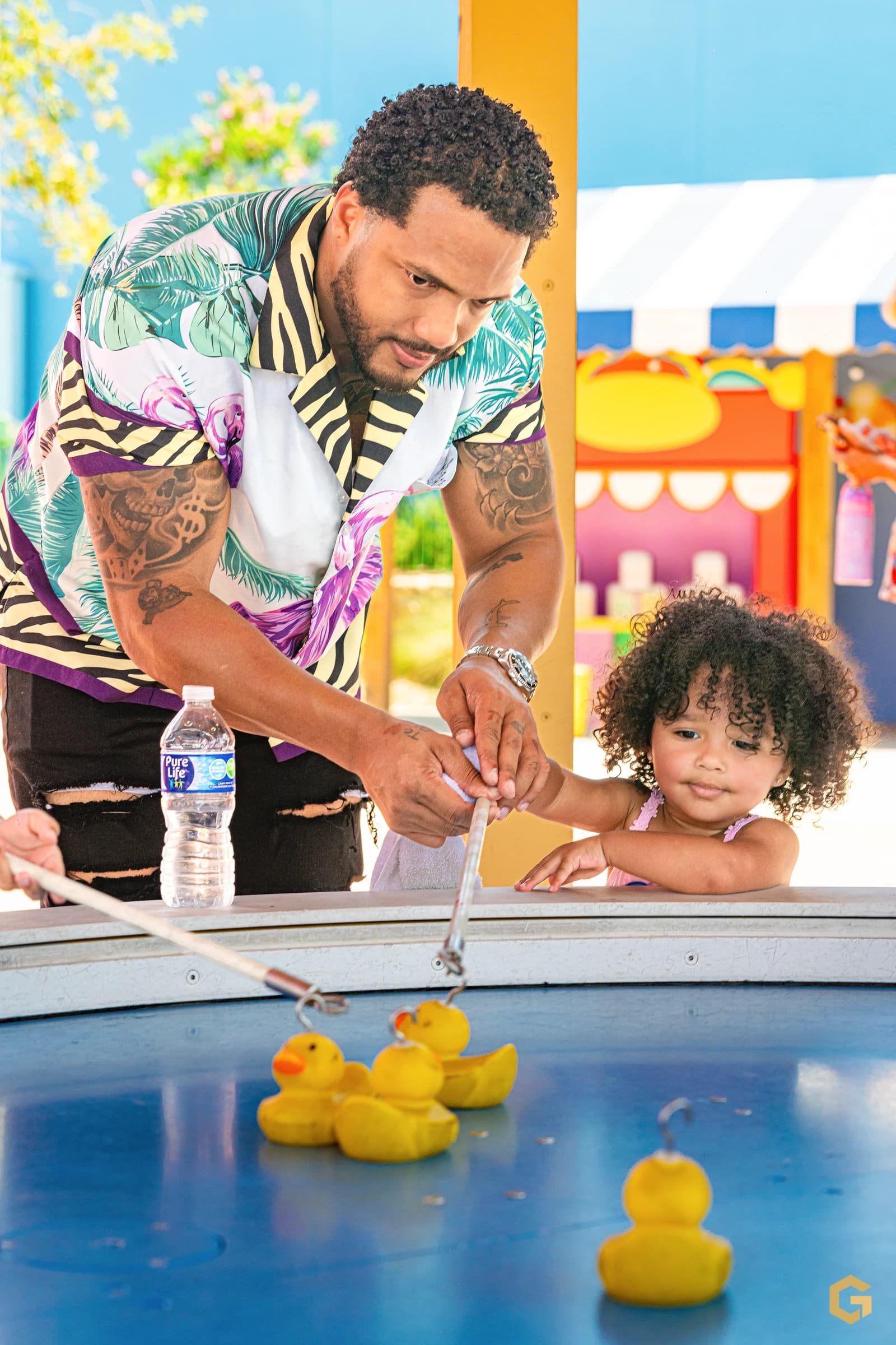 Edgardo helps his daughter play a duck fishing game