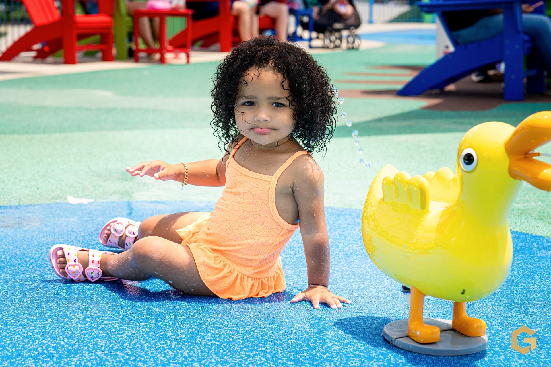 Birthday girl resting beside a yellow duck water feature