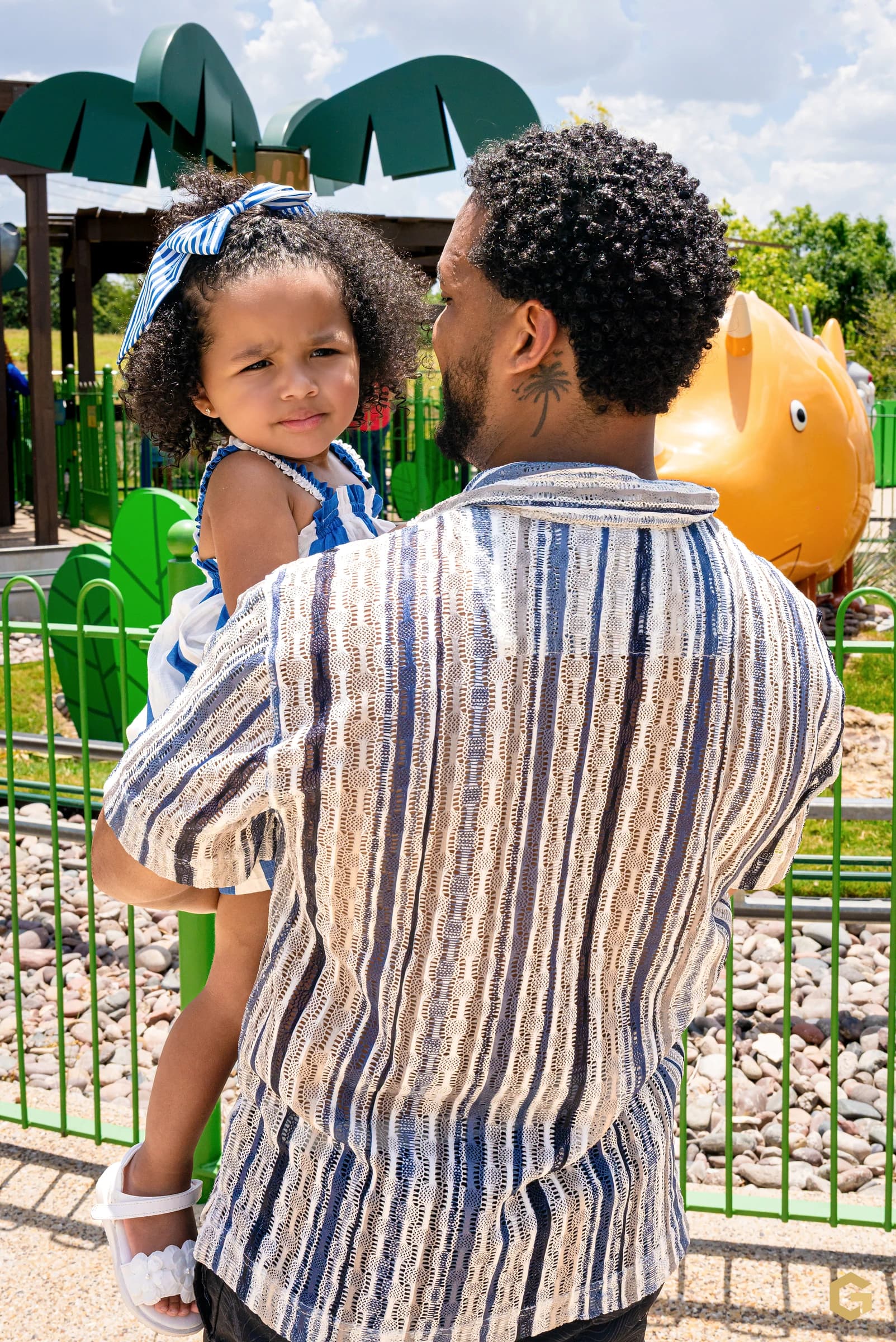 Edgardo carrying his daughter between rides