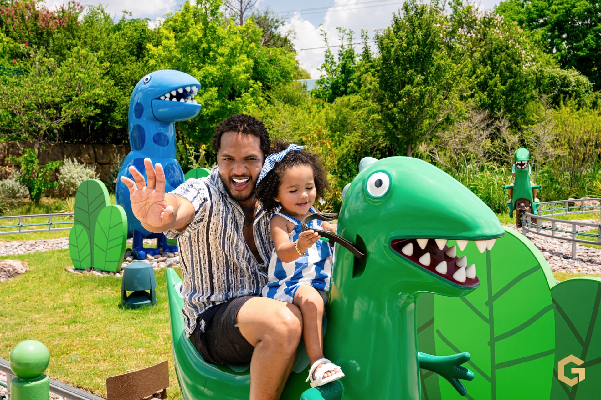 A joyful father-daughter portrait on the dinosaur ride