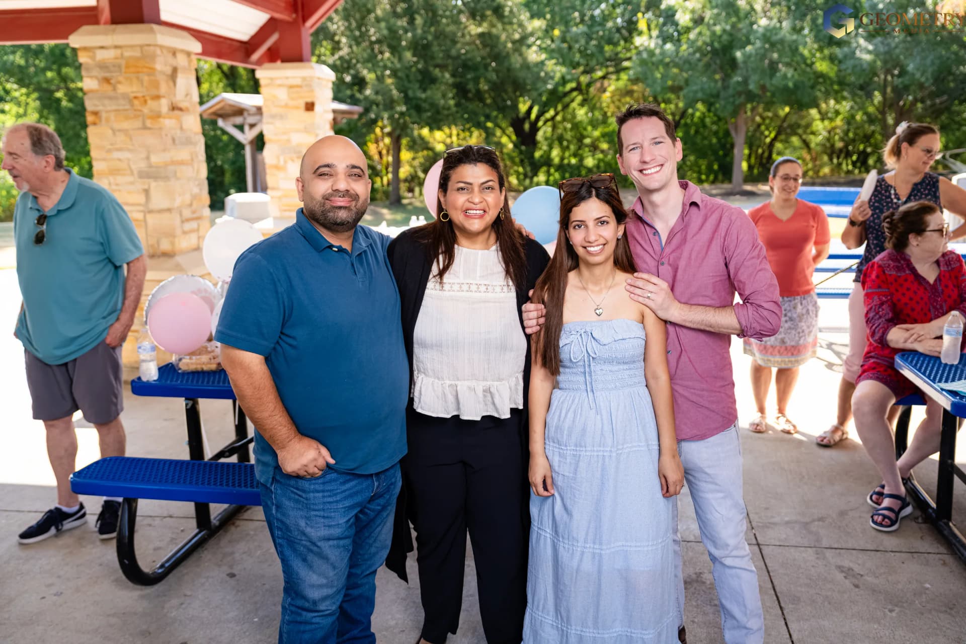 The expectant parents pose with family friends beneath the pavilion