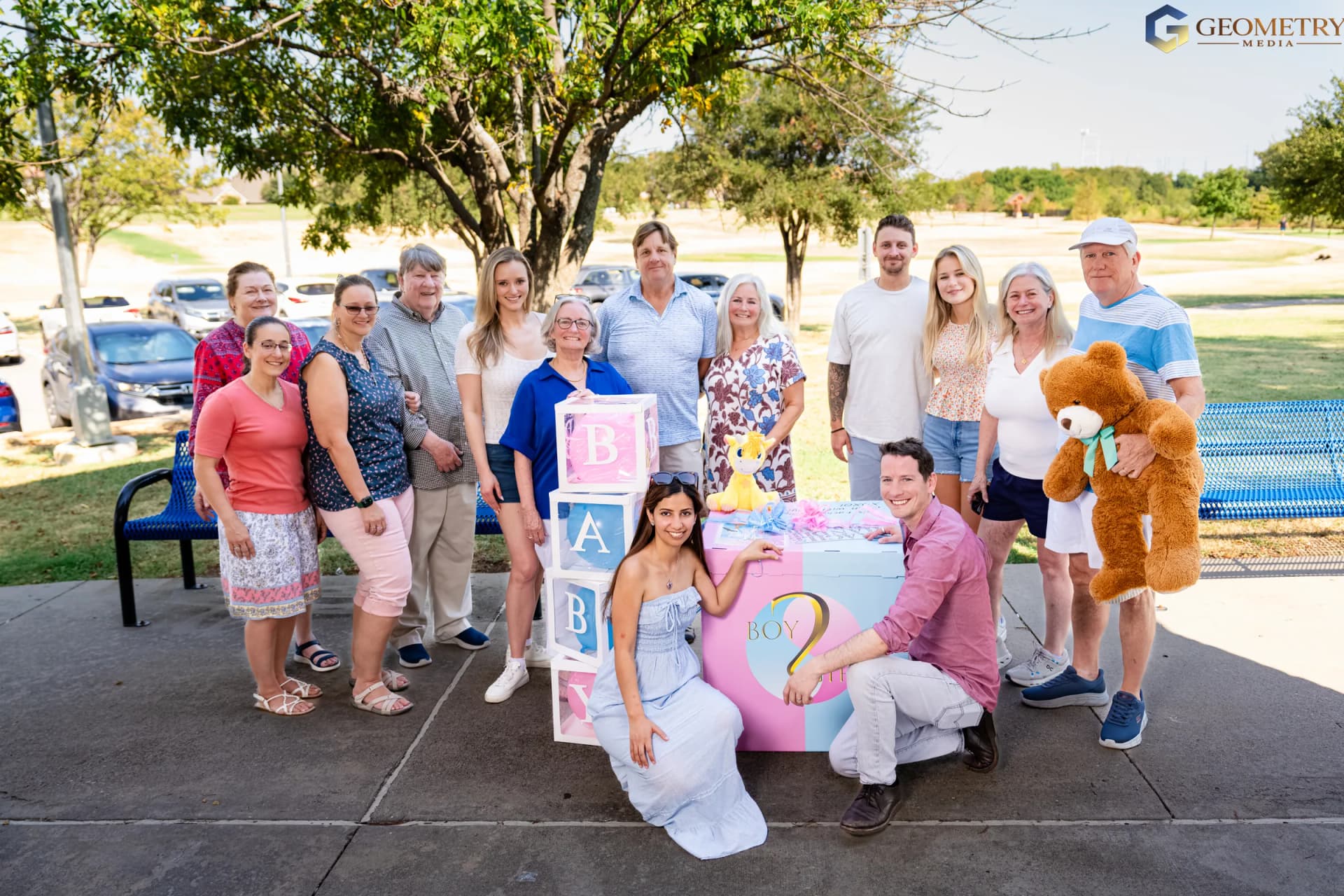 The expectant parents gather with their extended family around the gender reveal display