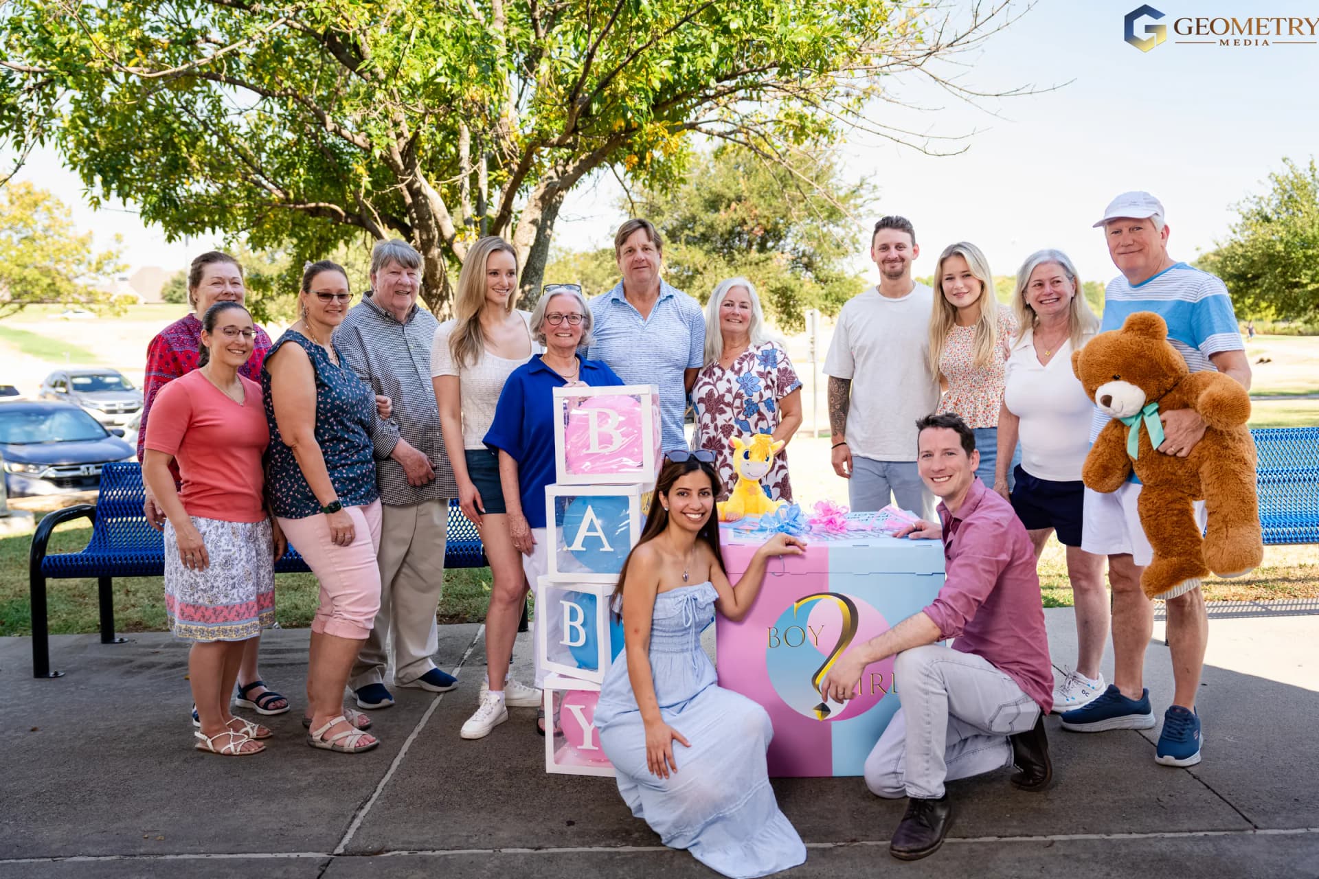 Extended family portrait beside the pink-and-blue reveal box