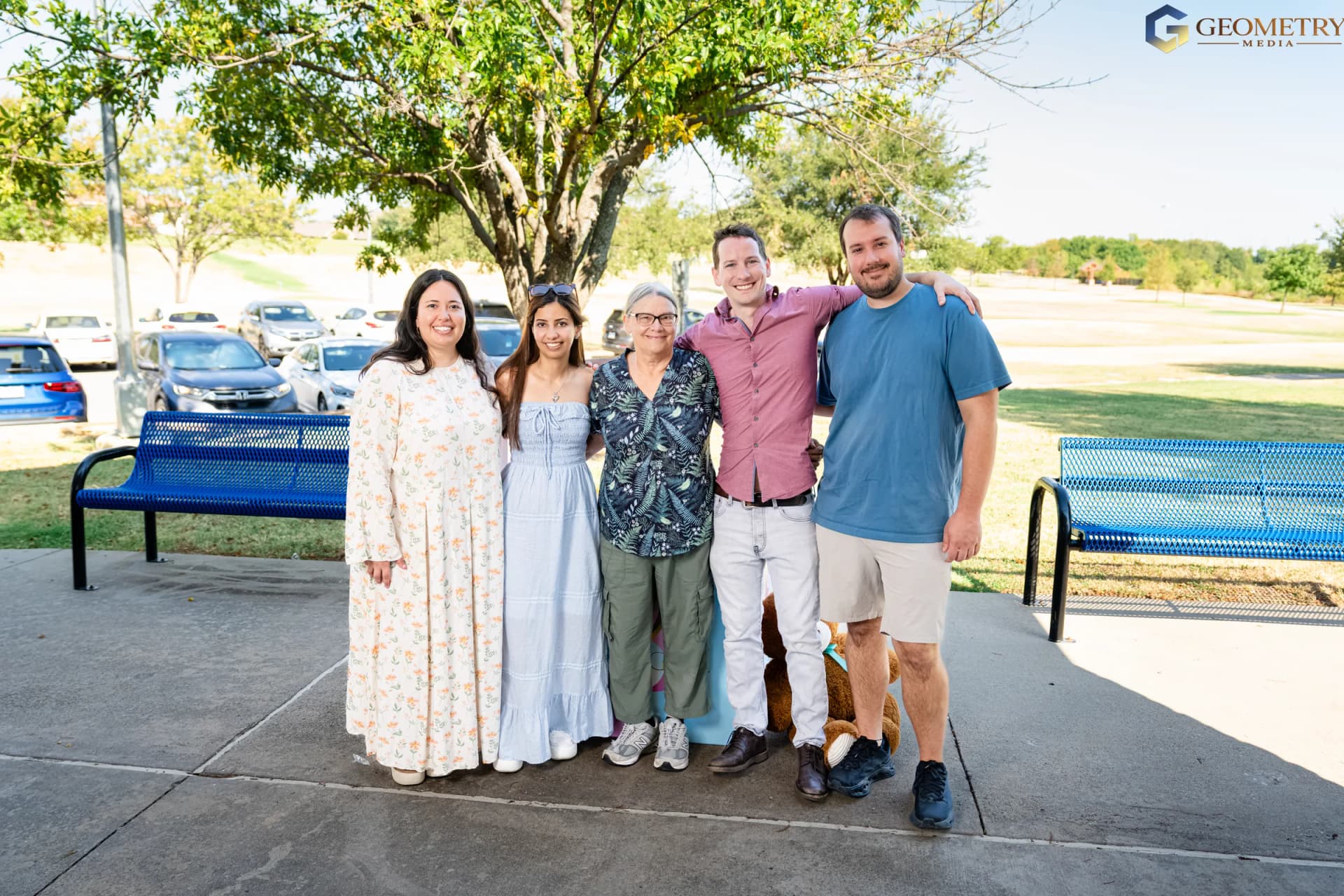 The expectant parents stand together with close family members