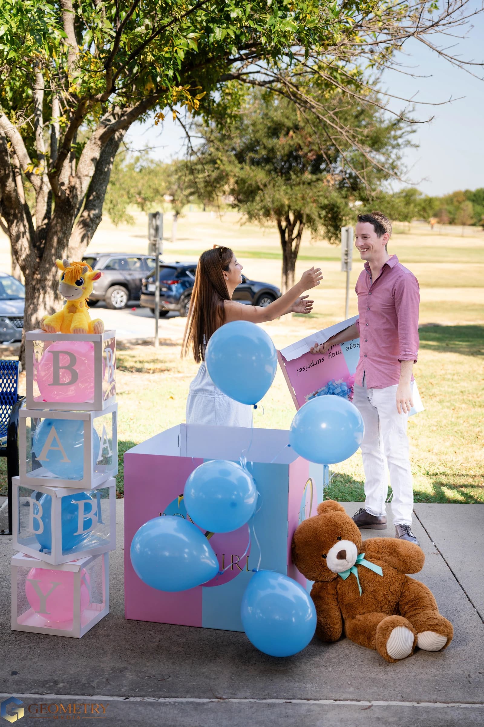The couple celebrate as blue balloons emerge from the box