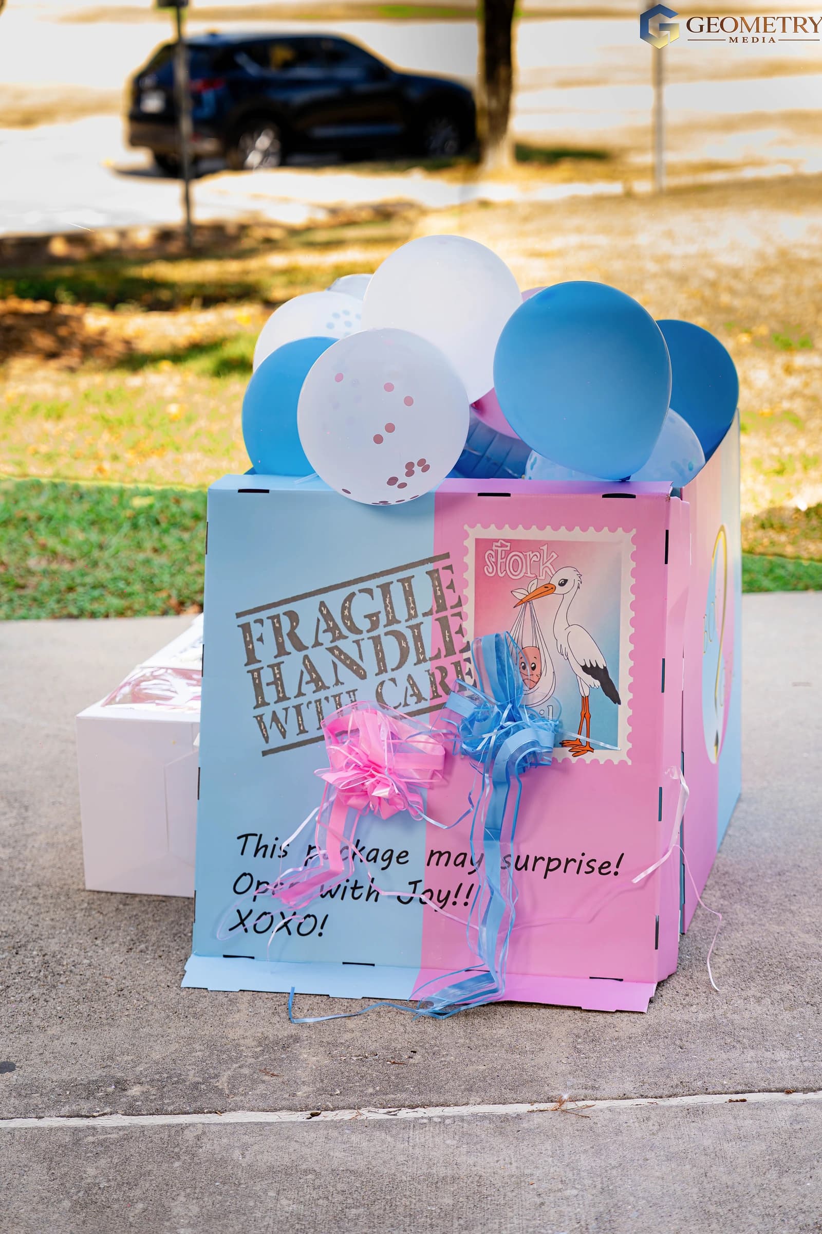 Blue balloons and ribbons fill the celebration box