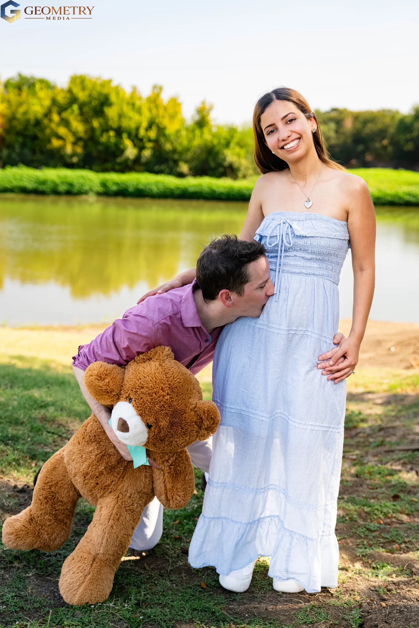 Bright lakeside maternity portrait celebrating their growing family