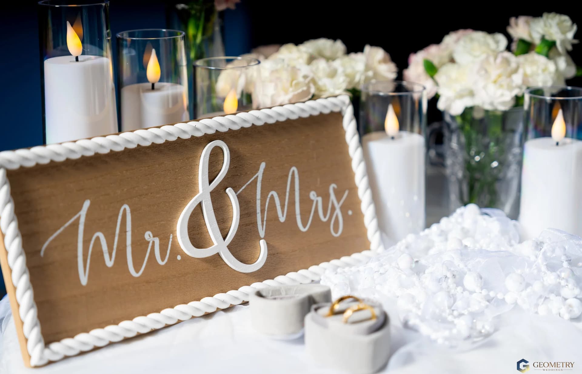 Wedding table with flowers, candles and a Mr and Mrs sign