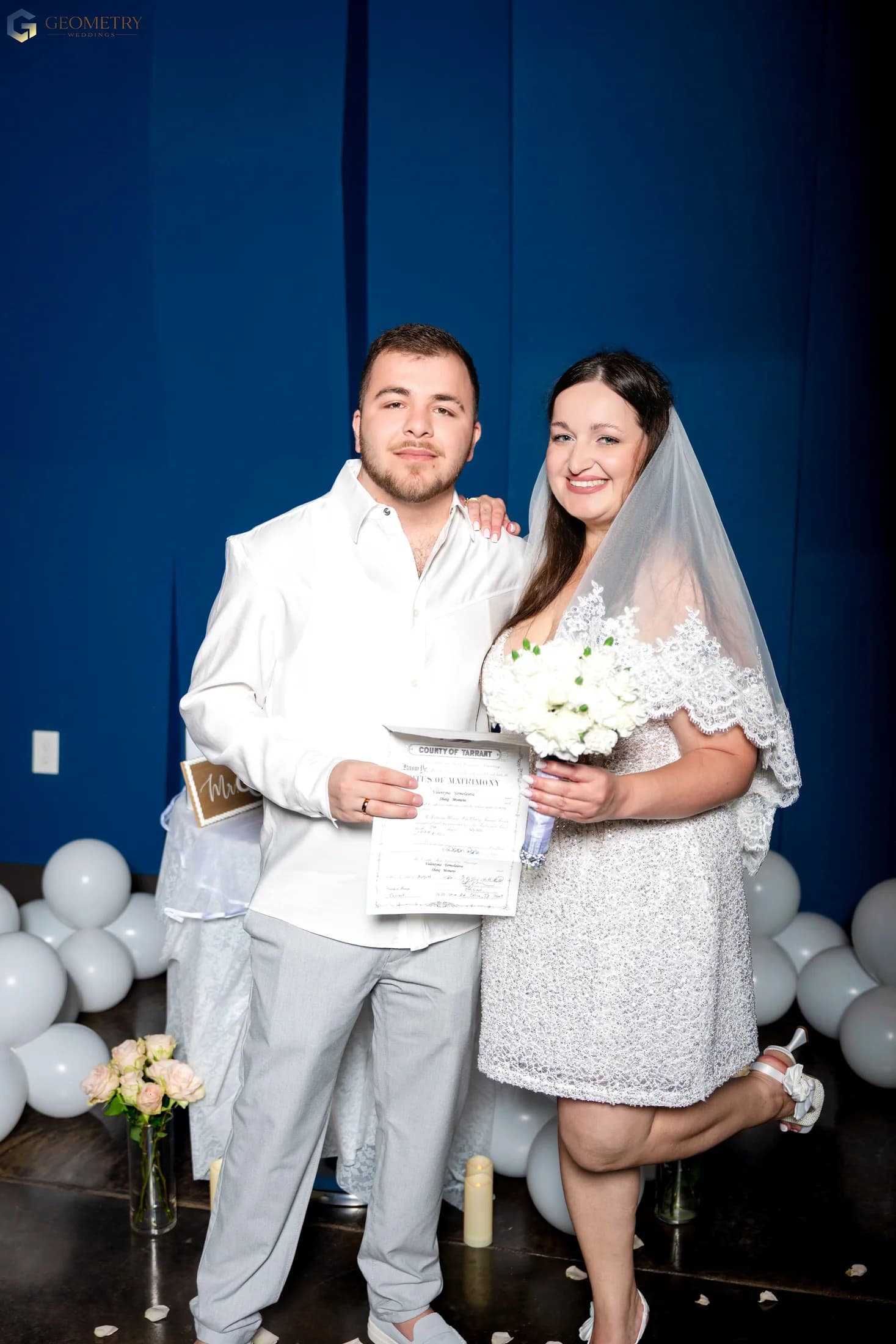 Newlyweds holding their marriage certificate