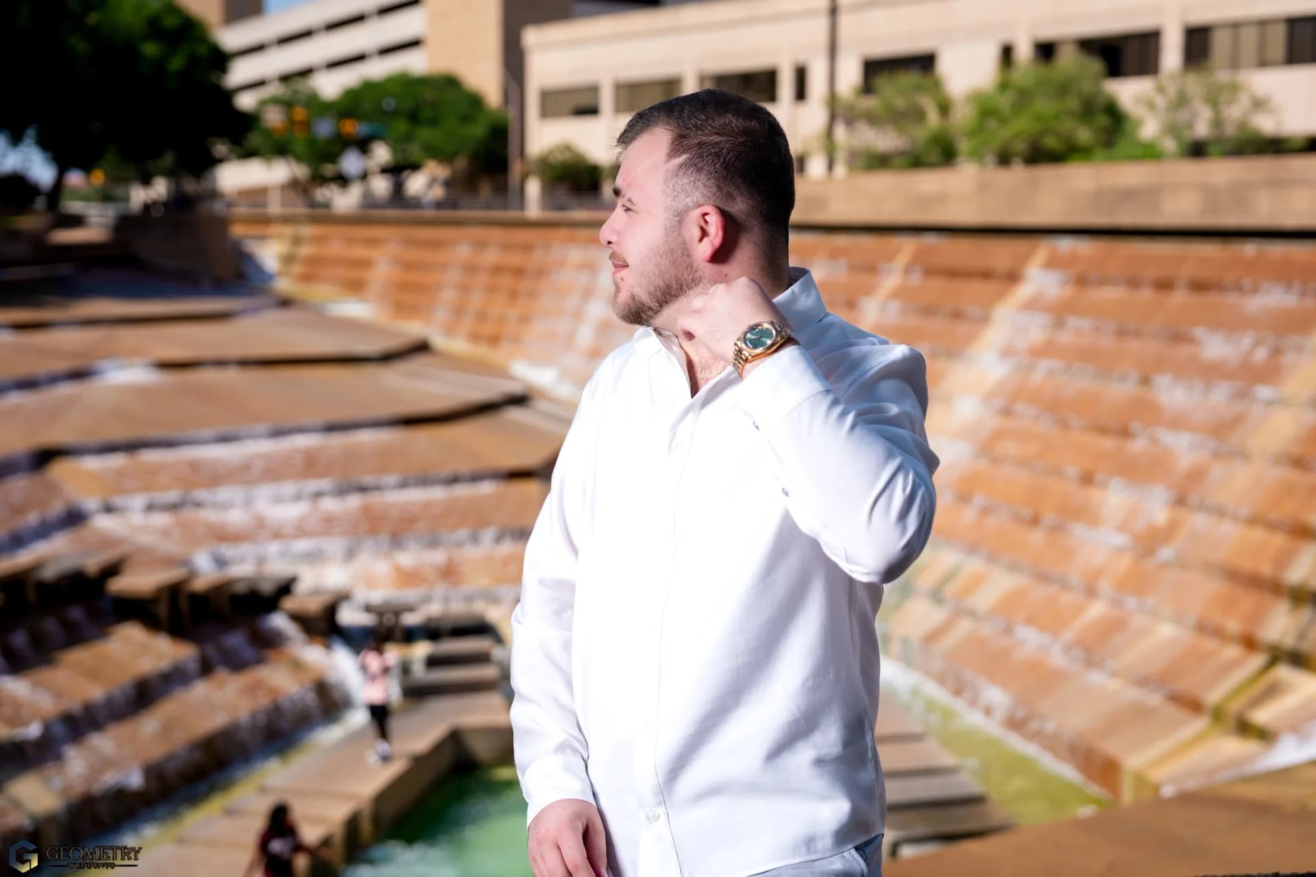 Editorial portrait of Shaiq beside a Dallas architectural fountain