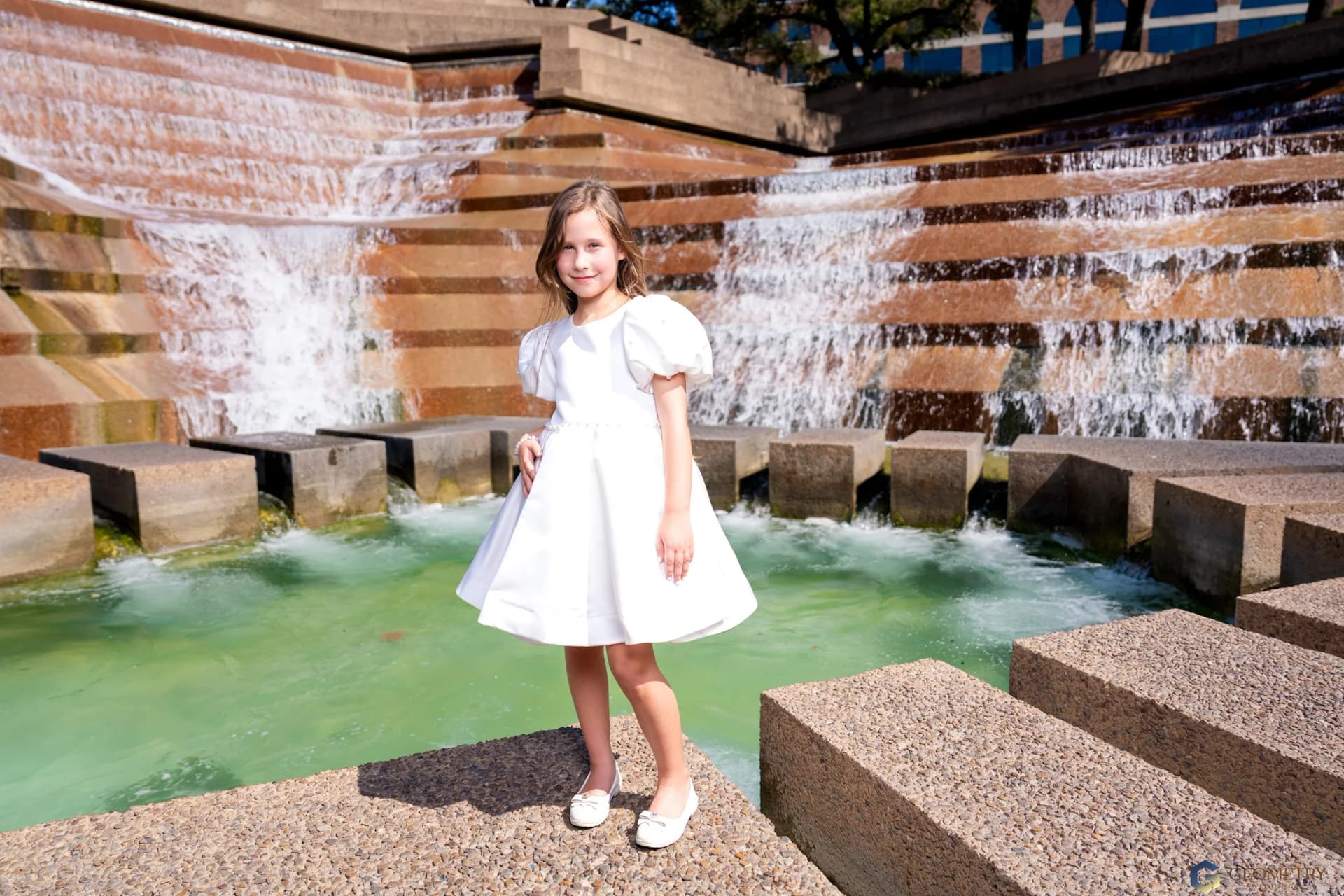 Full-length portrait of a young wedding guest by the fountain