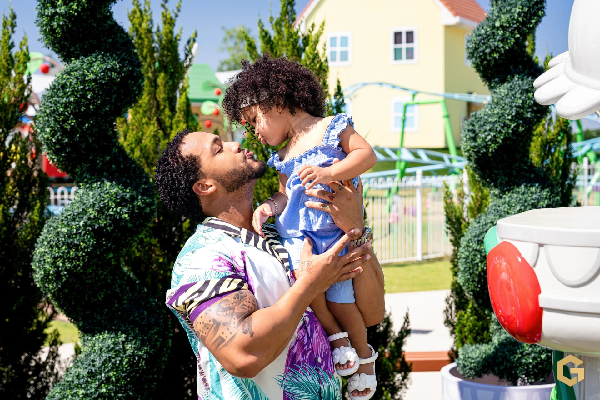 Edgardo lifting his daughter for a playful kiss